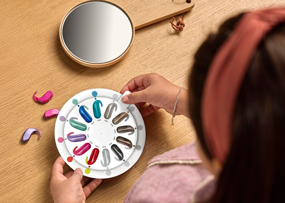 oticon_playsi_girl_looking_at_ha_colorwheel_ms_19649_tif