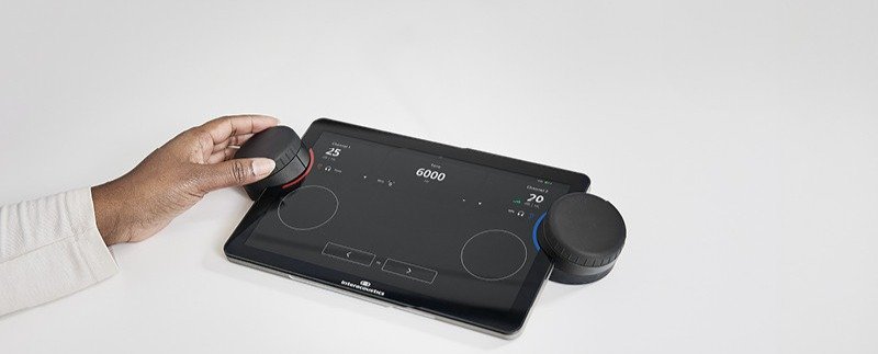 Interacoustics Touch Keyboard står på et skrivebord, og en audiograf navigerer ved hjelp av den venstre dreieknappen