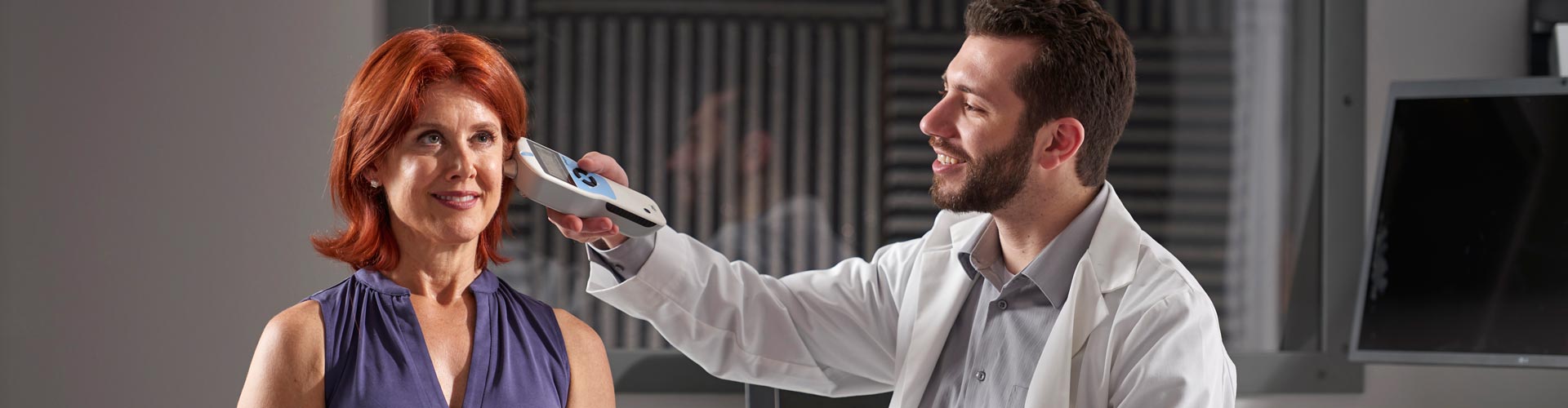 Audiologist performing screening tympanometry on a patient