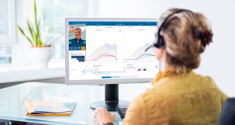Audiologist sitting in front of computer using the Fitting Assistant feature in Philips HearSuite