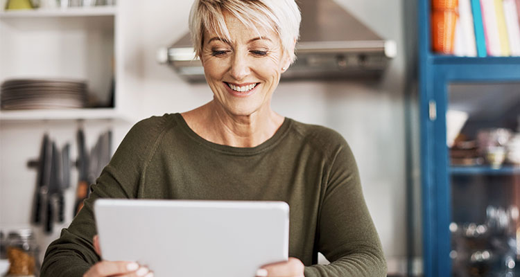 Woman in her fifties taking an online hearing test on her tablet while being at home