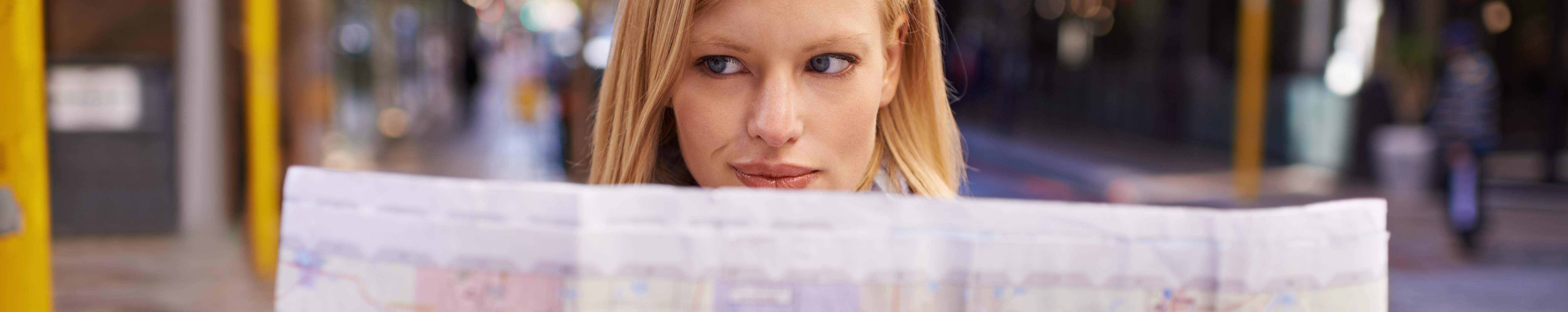 Shot of a young woman holding a map while touring abroad