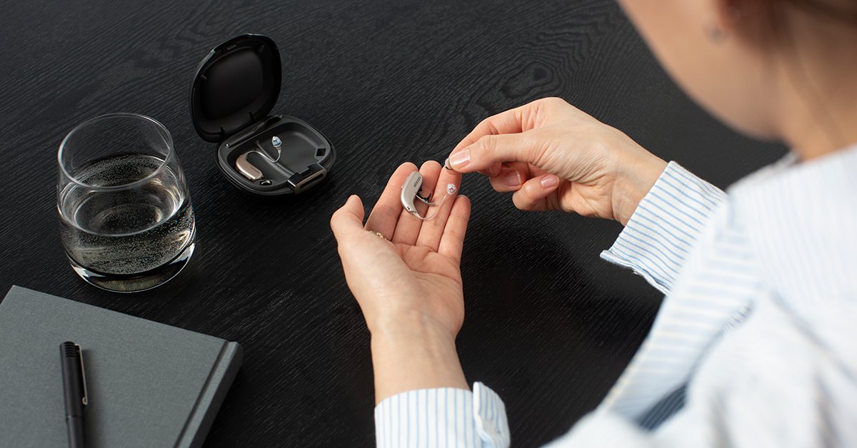 Woman holding a hearing aid, a possible treatment for tinnitus