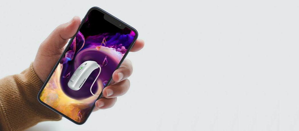 Un main tient un smartphone avec le visuel Otion MyMusic en fond d'écran en gros plan