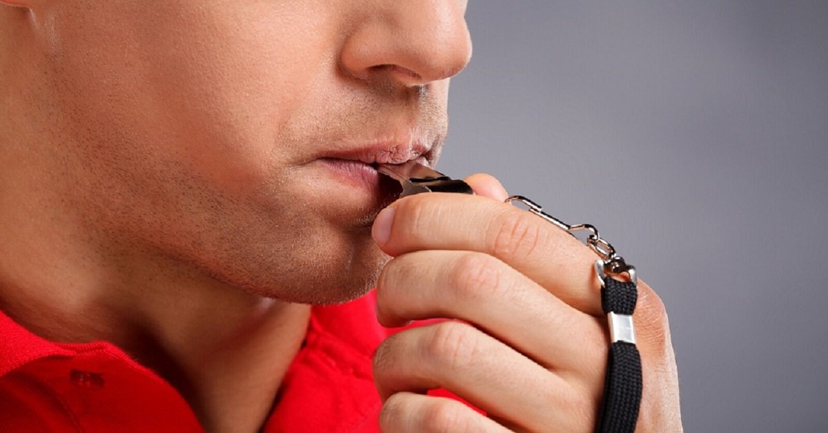 Un homme siffle sur un sifflet