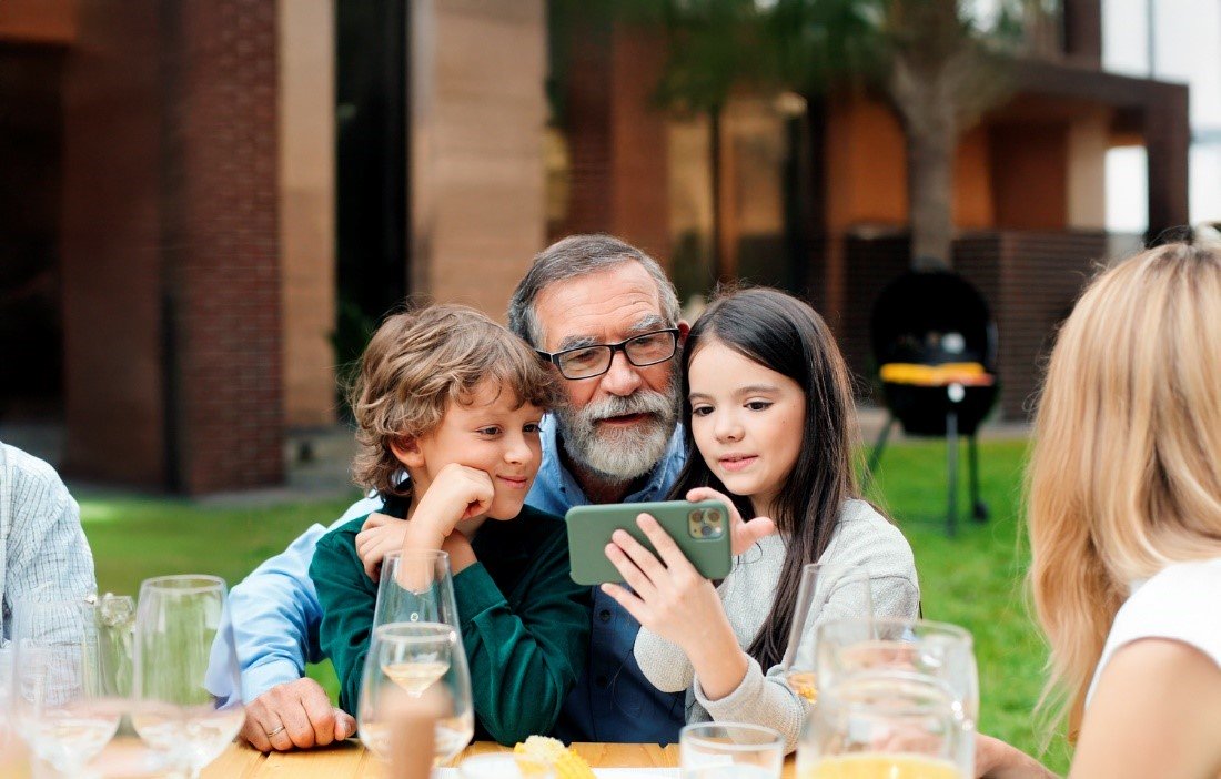 deux-enfants-montrent-un-telephone--un-grand-parent