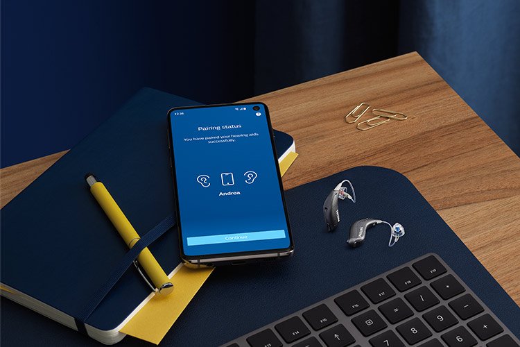 Aακουστικά βοηθήματα miniRITE T R δίπλα σε ένα smartphone με ανοιχτή την εφαρμογή PhilipsHearLink. 