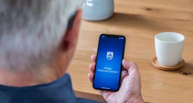 Ένας χρήστης των προϊόντων HearLink ανοίγει την εφαρμογή HearLink για μια εξ' αποστάσεως ρύθμιση των ακουστικών του βοηθημάτων. 