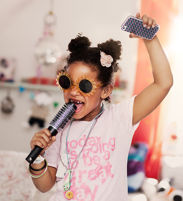 petit fille s'amusant à changer avec une brosse famille composée de la mère, le père et l'enfant, regardent la télévision dans leur salon à cheveux pour micro