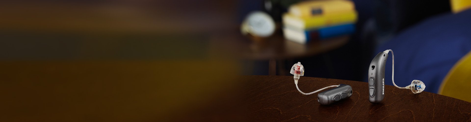 침실 테이블 위에 놓인 필립스 히어링크 miniRITE T 보청기. 필립스 보청기로 더 잘 들으십시오.