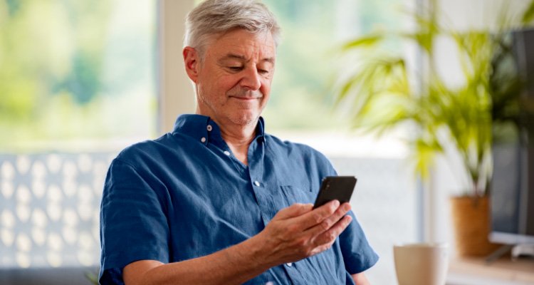 Een Philips hoortoestelgebruiker maakt via zijn smartphone verbinding met voor een Remote Fitting afspraak.