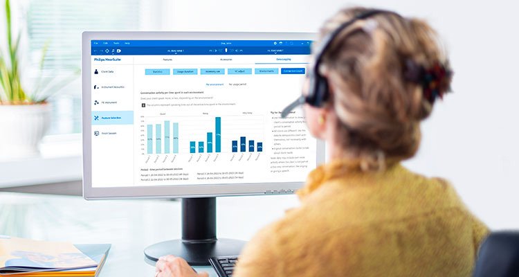 A female hearing care specialist uses Philips HearSuite fitting software in her workplace to analyze data